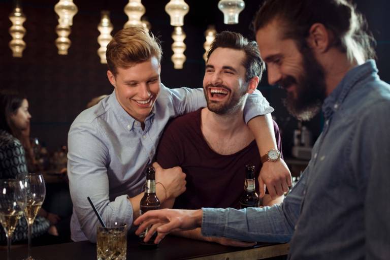 Drei Männer haben in einer Bar in München Spaß.