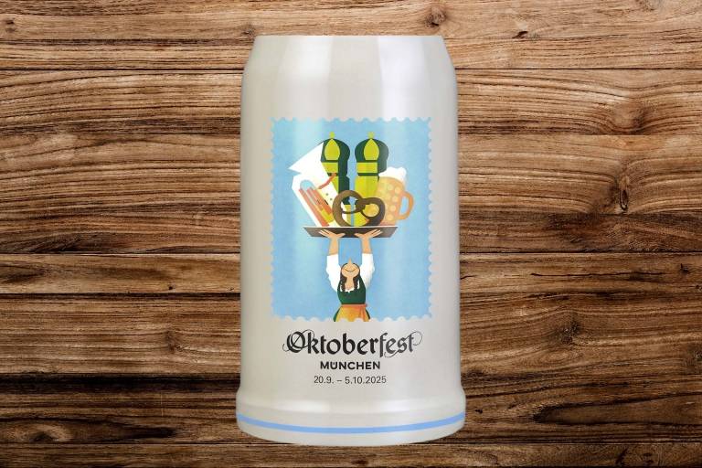 Der Oktoberfest Maßkrug 2025 auf einem Holzhintergrund.